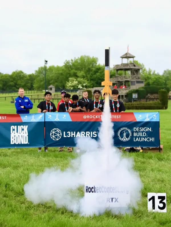 Club members watch their yellow-finned rocket leave the pad at the 2024 American Rocketry Challenge National Finals