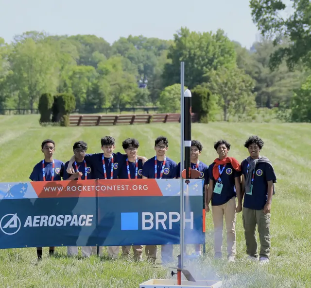 SBHS Aerospace Club members stand behind the launch rail as their rocket lifts off at the 2025 American Rocketry Challenge National Finals